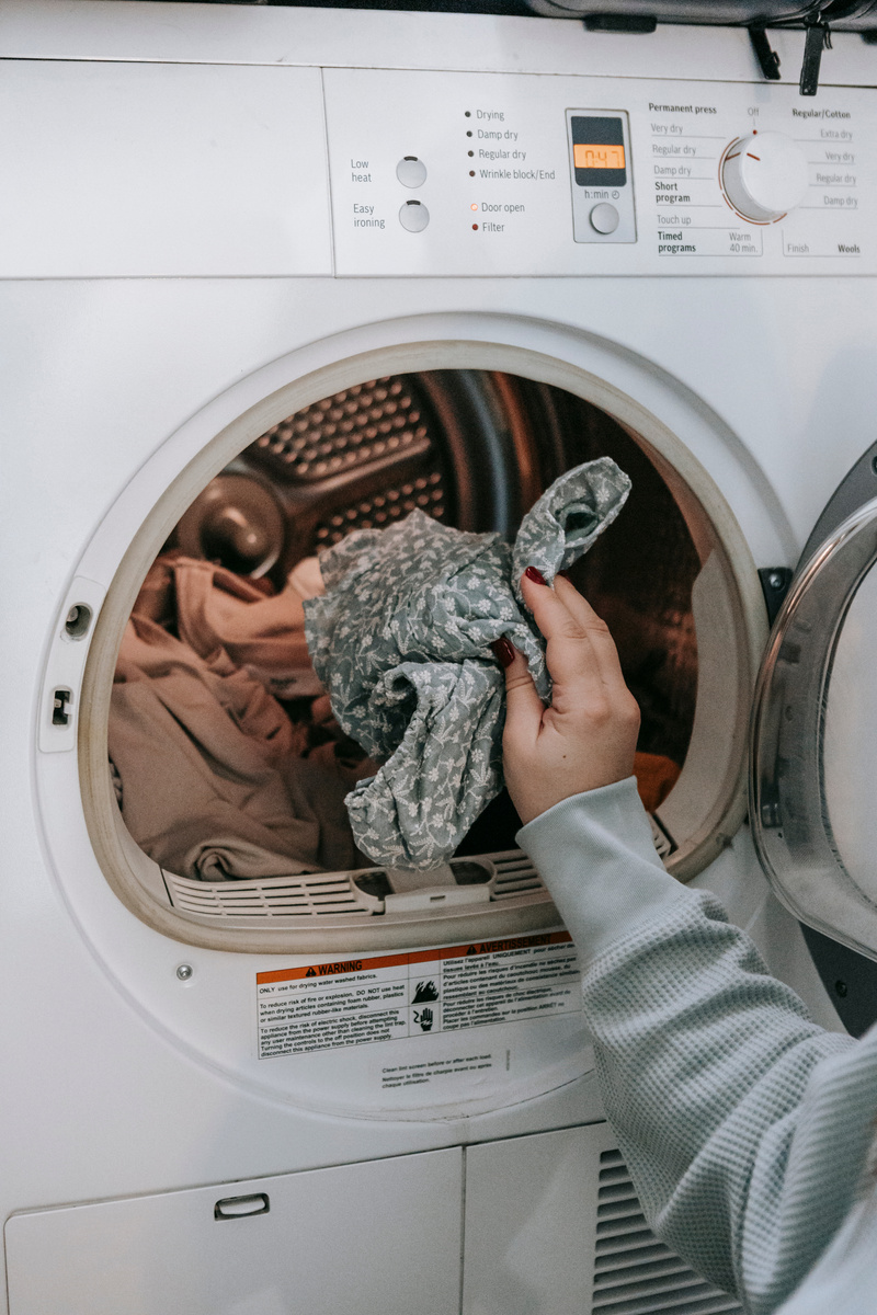 Anonymous woman putting clothes in washing machine